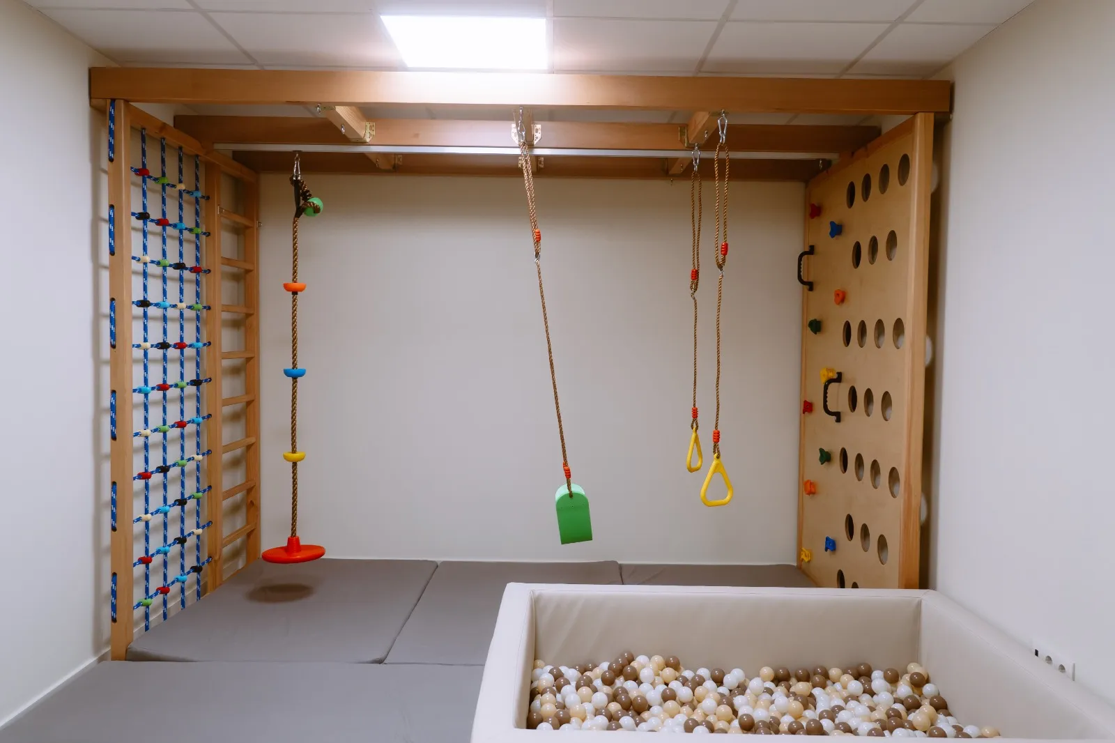 Sala para crianças com baloiços, parede de escalada e piscina de bolas